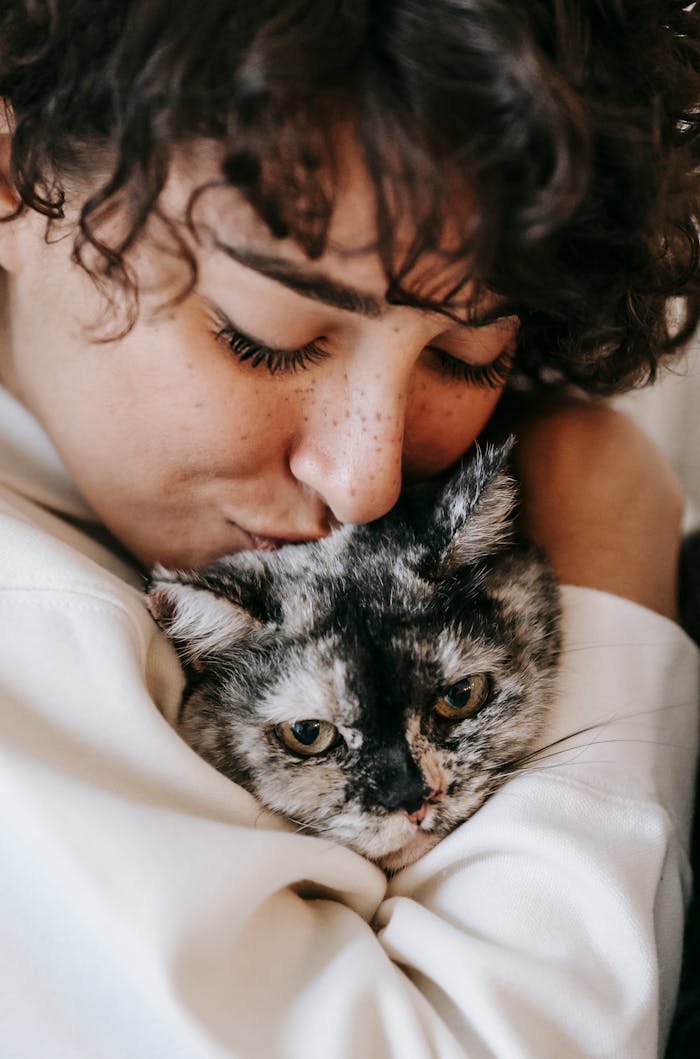 services-03 A woman affectionately cuddles her pet cat, showcasing a moment of warmth and companionship.